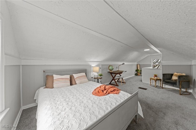 bedroom with baseboards, vaulted ceiling, carpet flooring, and a textured ceiling