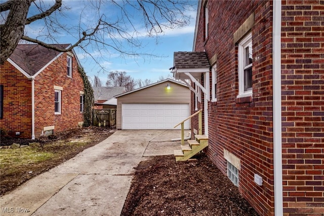 view of home's exterior with brick siding, an outdoor structure, and a garage
