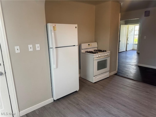 kitchen featuring baseboards, dark wood-style flooring, and white appliances