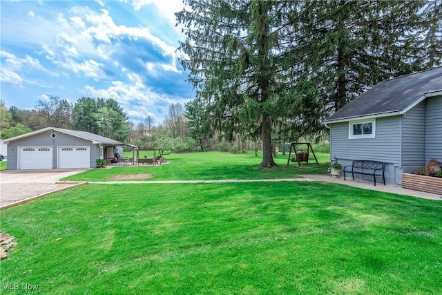 view of yard with a detached garage and an outbuilding