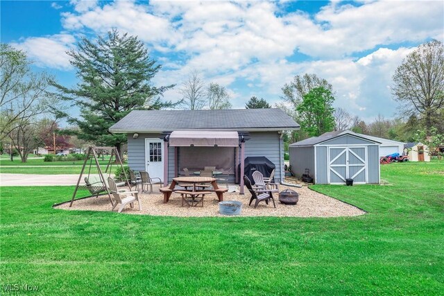 exterior space featuring a yard, an outbuilding, a shed, and an outdoor fire pit