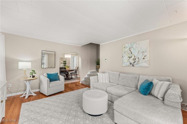 living room featuring arched walkways and wood finished floors