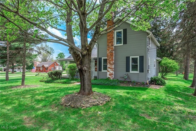 exterior space with a chimney and a front lawn