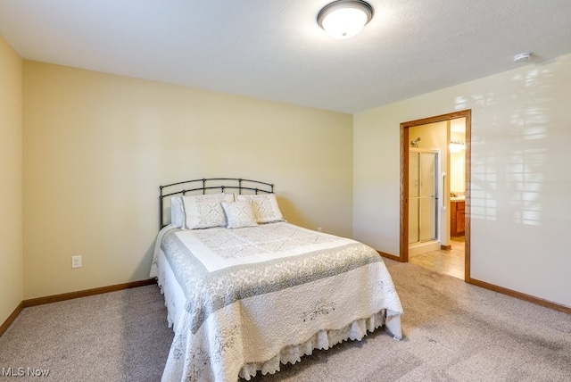 bedroom featuring baseboards, light carpet, and ensuite bath