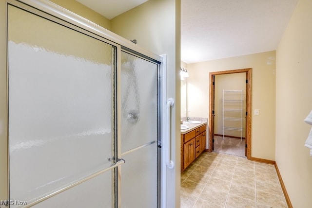 full bathroom featuring baseboards, a shower stall, tile patterned flooring, and vanity