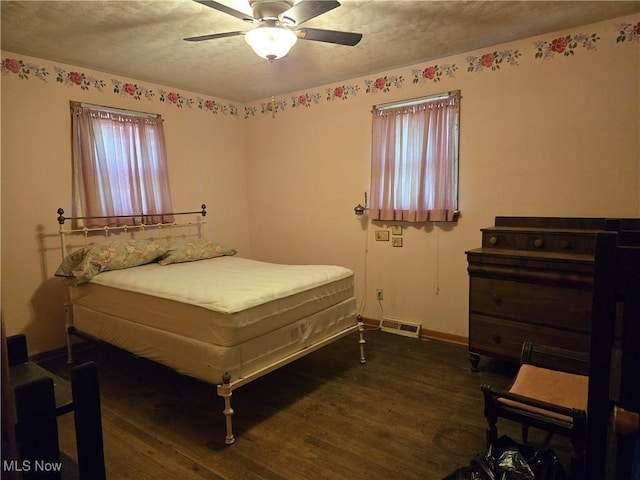 bedroom featuring visible vents, wood finished floors, baseboards, ceiling fan, and a textured ceiling