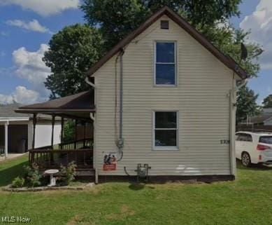 back of property featuring a yard
