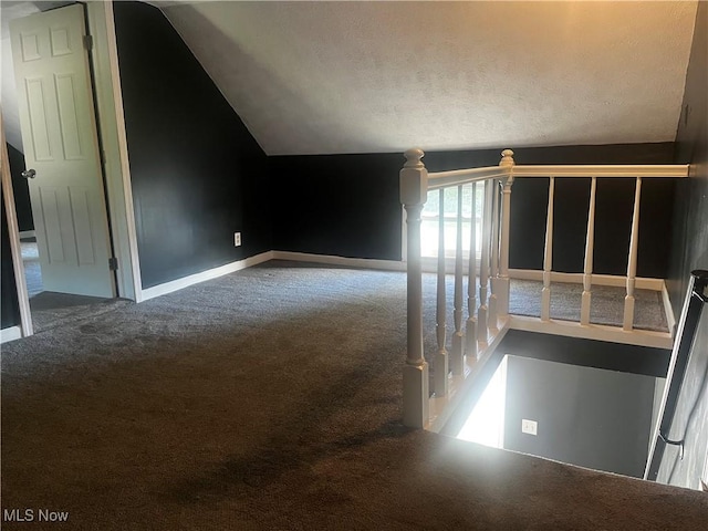 bonus room with carpet floors, baseboards, and vaulted ceiling