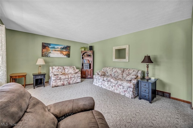 carpeted living room featuring baseboards and a textured ceiling