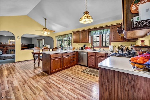 kitchen featuring arched walkways, vaulted ceiling, dishwasher, light countertops, and a peninsula