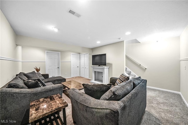 carpeted living area with stairs, recessed lighting, baseboards, and visible vents