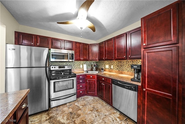 kitchen with ceiling fan, appliances with stainless steel finishes, tasteful backsplash, dark brown cabinets, and a sink