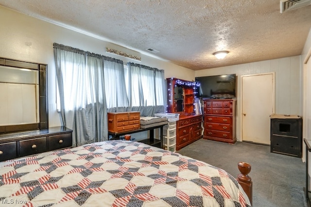 bedroom with a textured ceiling, visible vents, and carpet