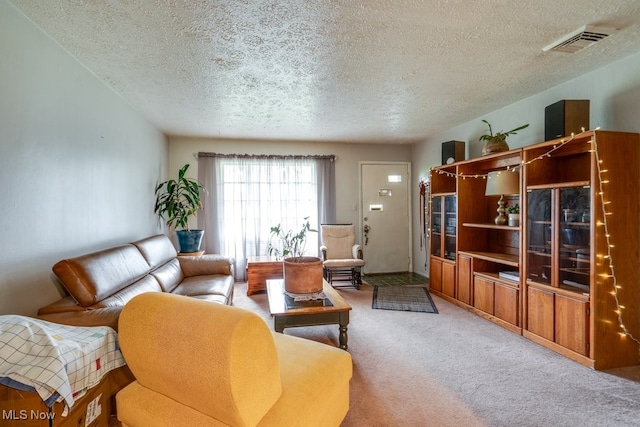 carpeted living area with a textured ceiling and visible vents
