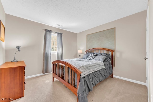 bedroom with visible vents, a textured ceiling, baseboards, and light carpet
