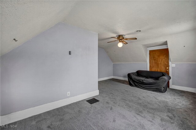 3207 6th St SW, Canton, OH 44710 - additional living space with a textured ceiling, vaulted ceiling, carpet floors, baseboards, and ceiling fan