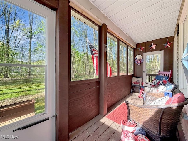 sunroom featuring wooden walls and wood finished floors