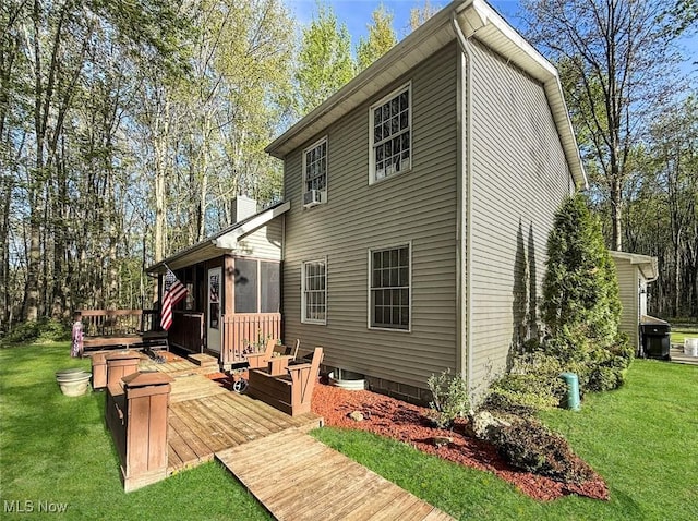 back of house with a wooden deck, a yard, and a chimney