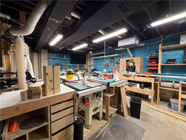 misc room featuring unfinished concrete floors, a workshop area, and visible vents