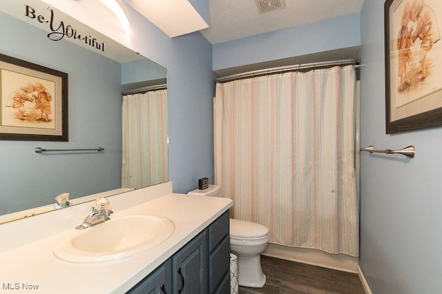 bathroom featuring visible vents, vanity, wood finished floors, toilet, and a shower with curtain