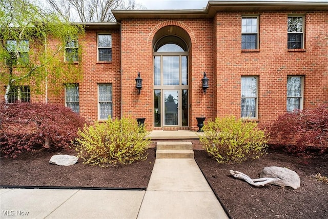 view of exterior entry featuring brick siding