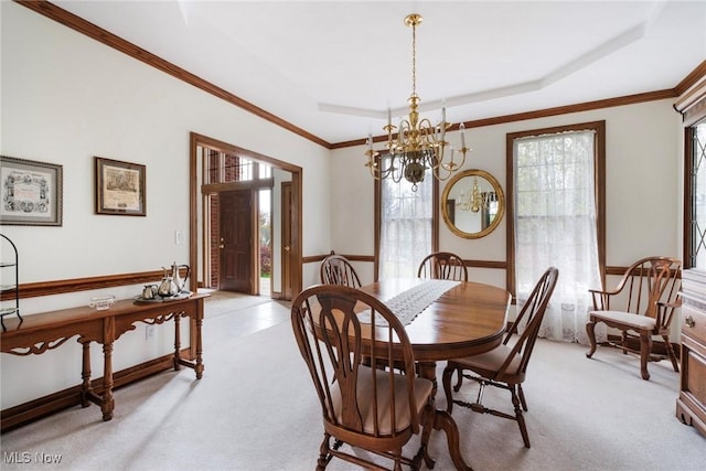 dining space featuring light colored carpet, an inviting chandelier, ornamental molding, and a healthy amount of sunlight