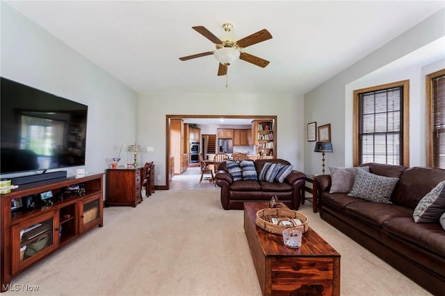 living area with light carpet and a ceiling fan