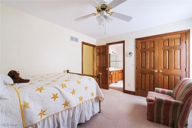 bedroom with a ceiling fan, visible vents, baseboards, ensuite bathroom, and light carpet