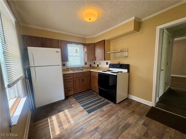 kitchen featuring freestanding refrigerator, electric range, a textured ceiling, a sink, and dark wood finished floors