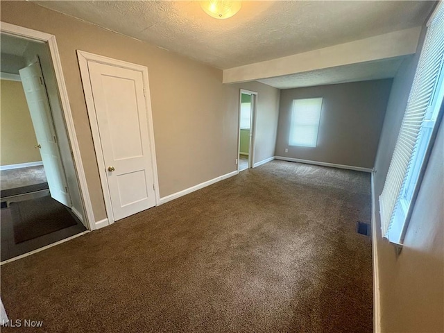 unfurnished bedroom featuring baseboards, carpet flooring, and a textured ceiling
