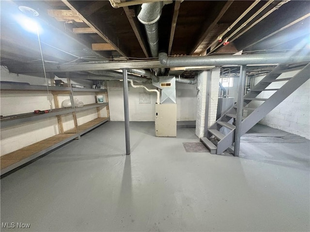 unfinished below grade area featuring stairs and heating unit