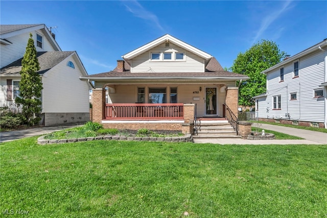bungalow with a porch and a front lawn