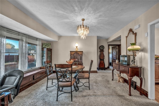 carpeted dining space with baseboards, a textured ceiling, and a notable chandelier