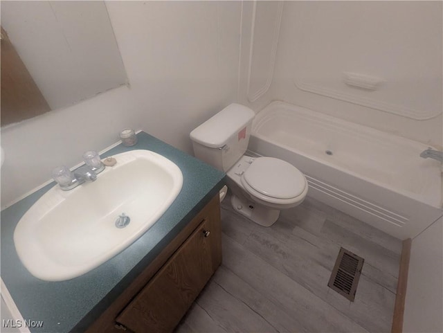full bathroom featuring walk in shower, vanity, toilet, wood finished floors, and visible vents