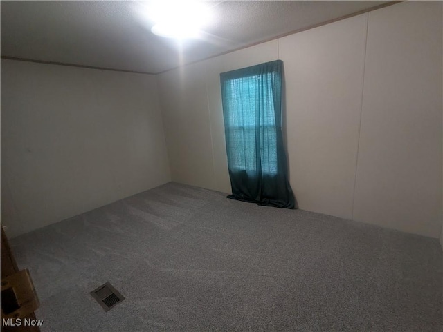unfurnished room featuring visible vents and carpet