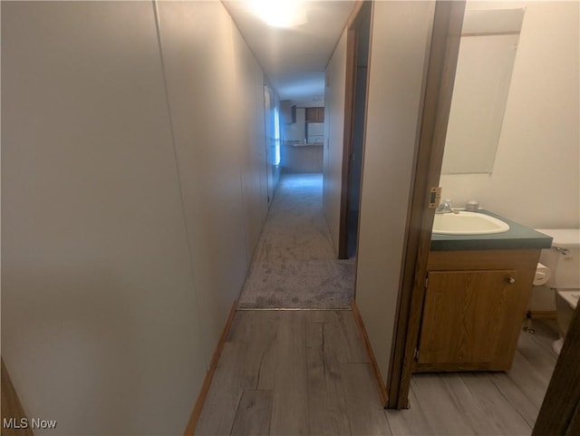 hall featuring a sink and light wood-style flooring