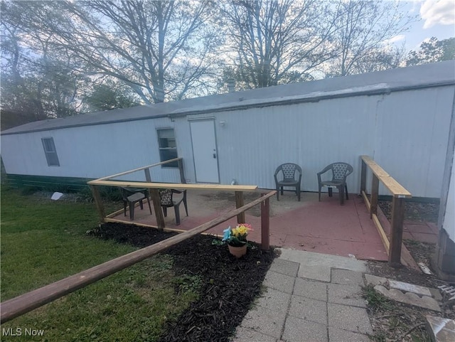 back of property featuring a patio and a yard