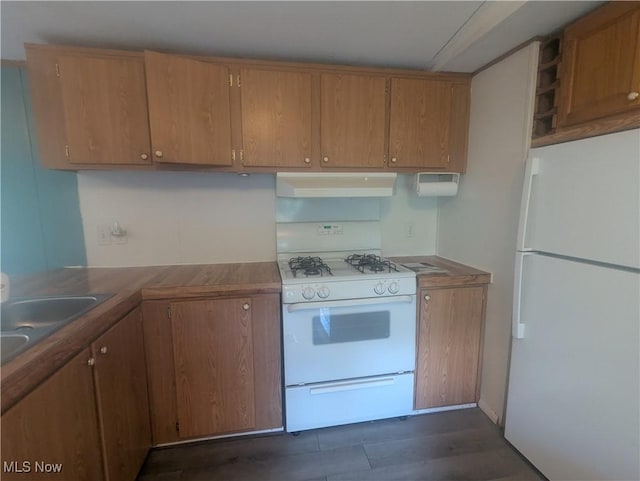 kitchen with a sink, brown cabinets, under cabinet range hood, and white appliances