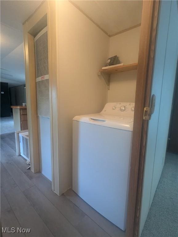 clothes washing area featuring washer / dryer, laundry area, and wood finished floors