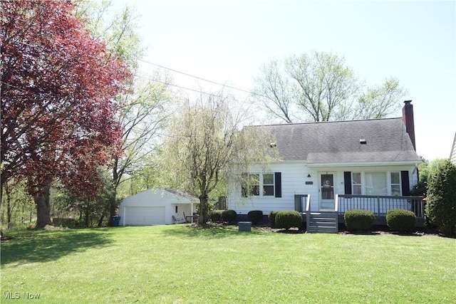 view of front facade with a garage, covered porch, a front yard, a chimney, and an outbuilding
