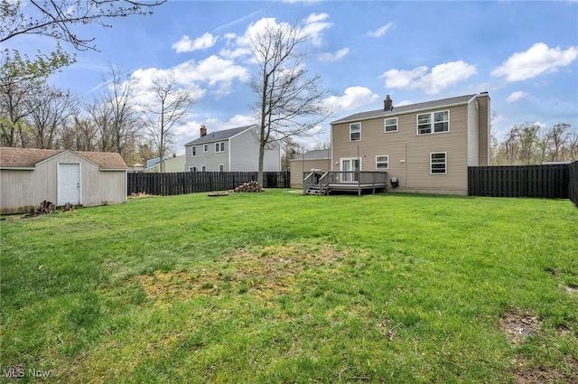 view of yard with a storage shed, an outdoor structure, a wooden deck, and a fenced backyard