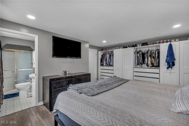 bedroom featuring recessed lighting, baseboards, wood finished floors, and ensuite bathroom