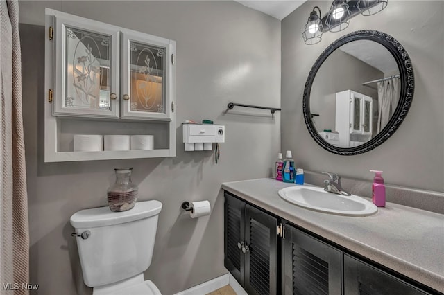 full bath with baseboards, vanity, and toilet