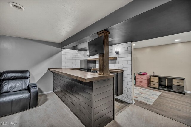 kitchen with baseboards, recessed lighting, butcher block countertops, and open floor plan