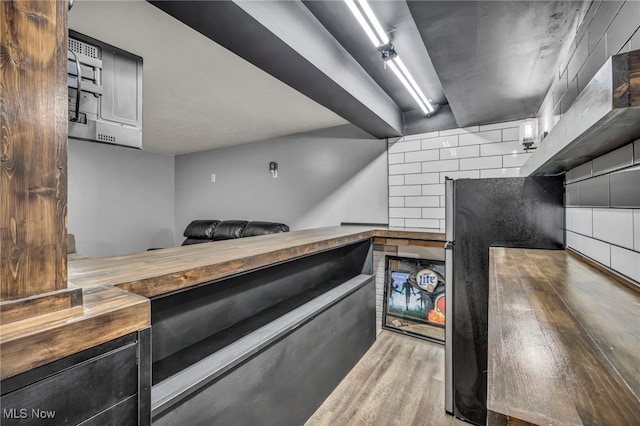 kitchen with butcher block countertops, wood finished floors, and tasteful backsplash