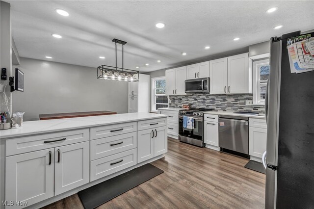 kitchen with appliances with stainless steel finishes, tasteful backsplash, recessed lighting, and white cabinetry