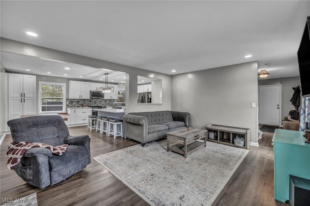 living area featuring recessed lighting and dark wood-style flooring