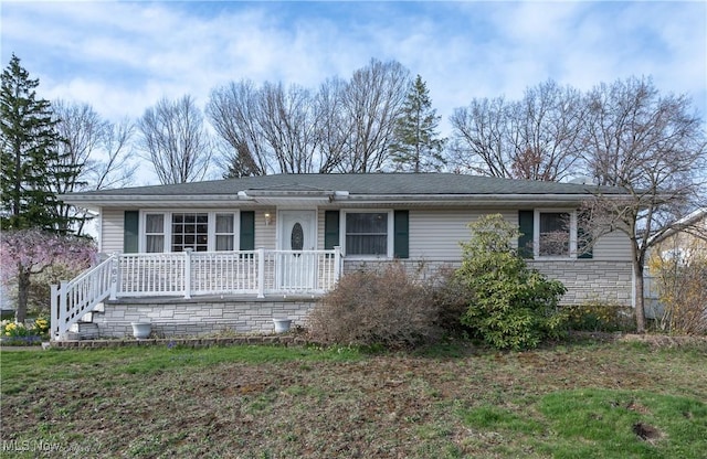 single story home featuring covered porch and a front yard