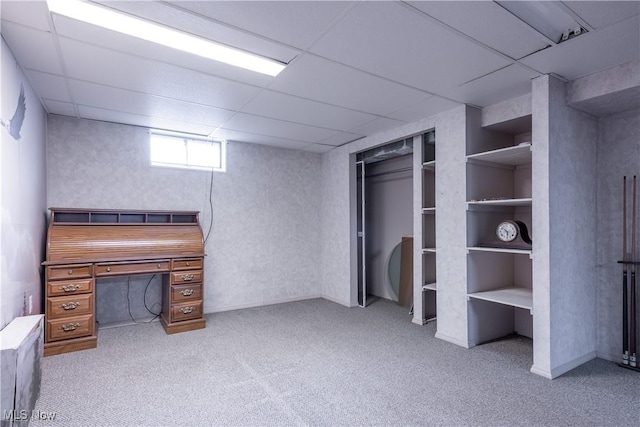 unfurnished bedroom featuring carpet flooring, a paneled ceiling, and a closet