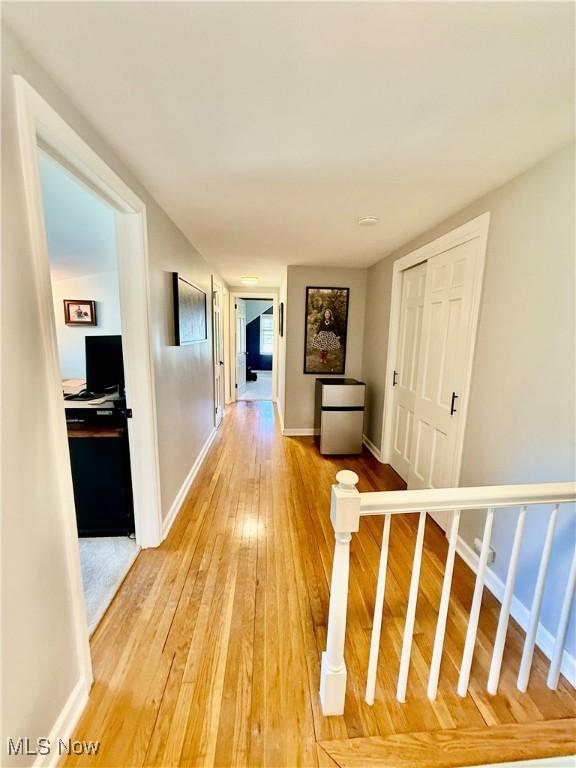 hallway with light wood-style floors and baseboards